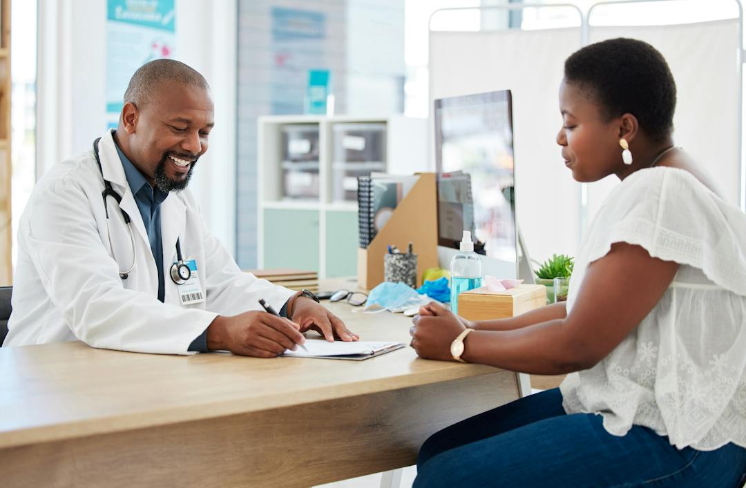 Doctor speaking with a patient at a clinic reception desk